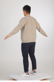 Yoshinaga Kuri blue jeans brown sweater casual dressed standing white…